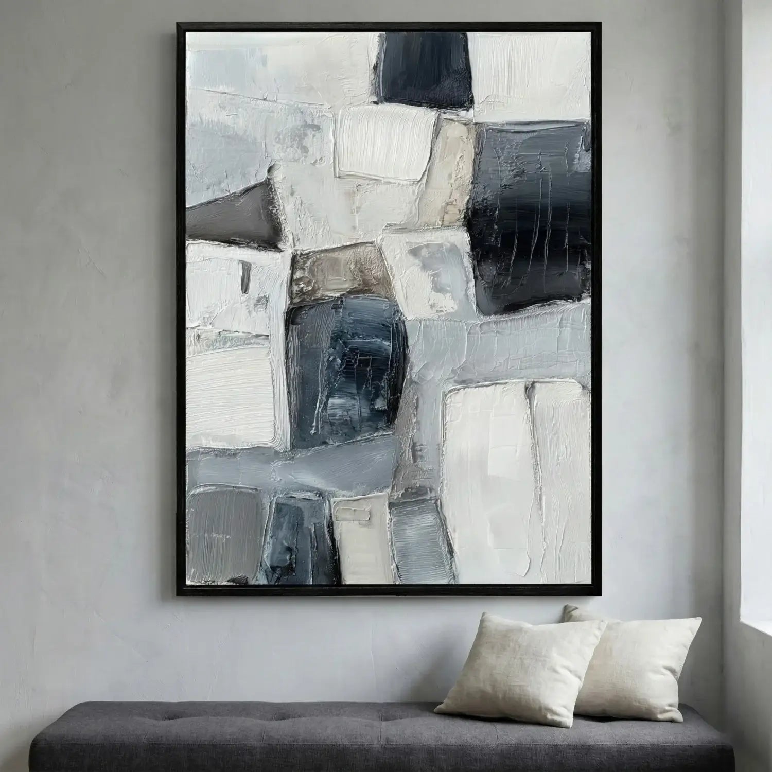 Abstract art print in a black frame on a wall above a sofa.