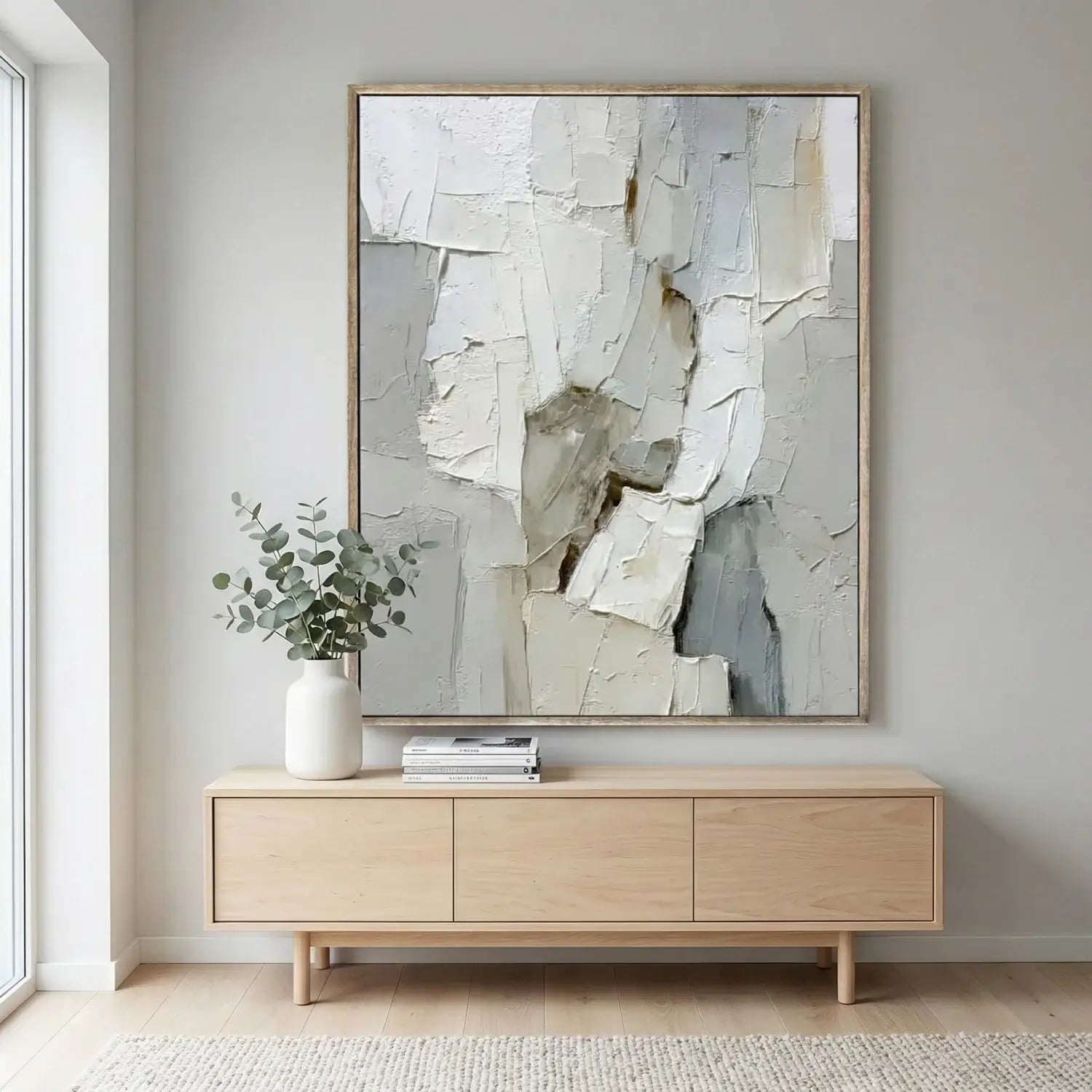 Modern interior with a wooden sideboard, abstract painting, and plant.
