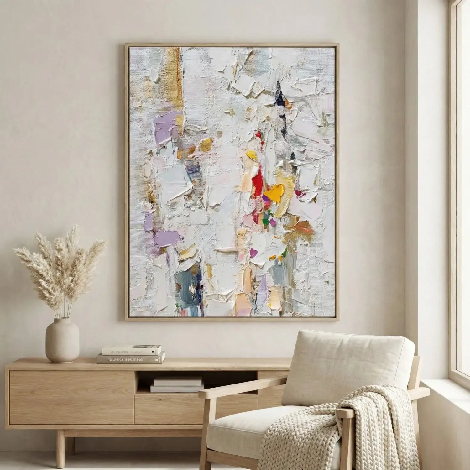 Abstract art piece on a wall above a wooden console table with a chair and decorative elements.