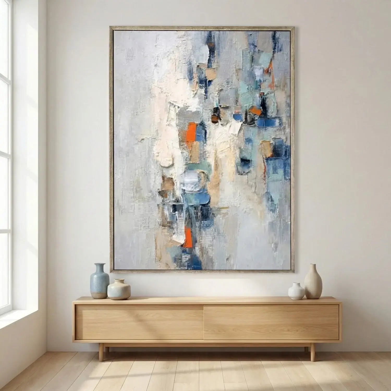 Abstract painting on a wall above a wooden console table with decorative vases.
