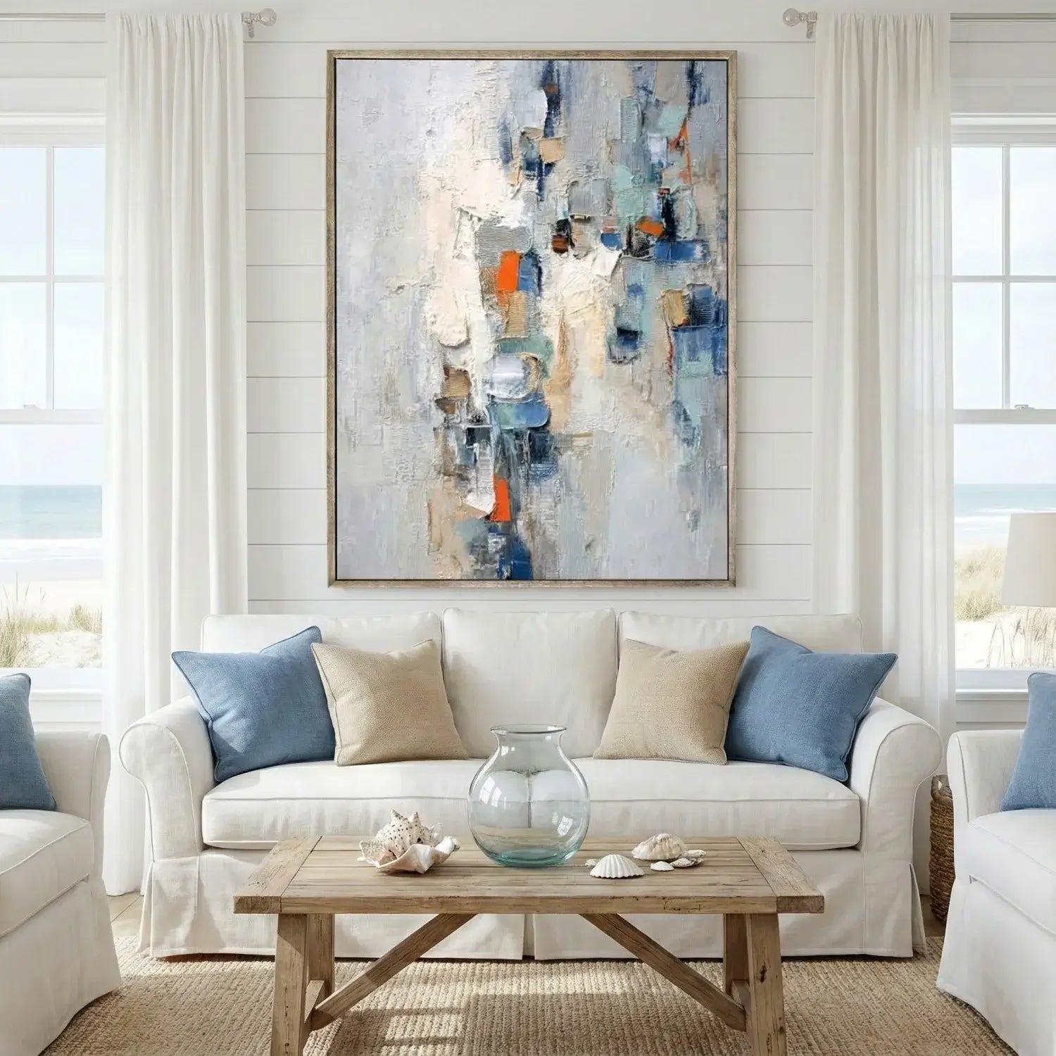 Living room with a white sofa, abstract painting, and wooden coffee table.