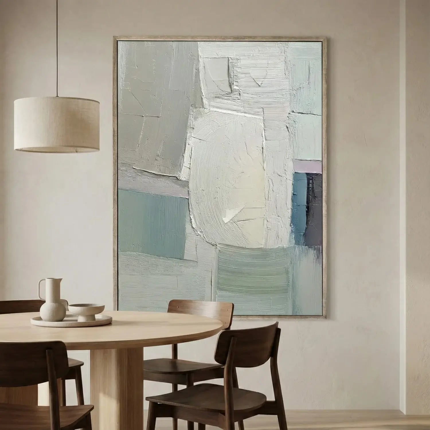 Abstract painting in a modern dining room with a round table and chairs.
