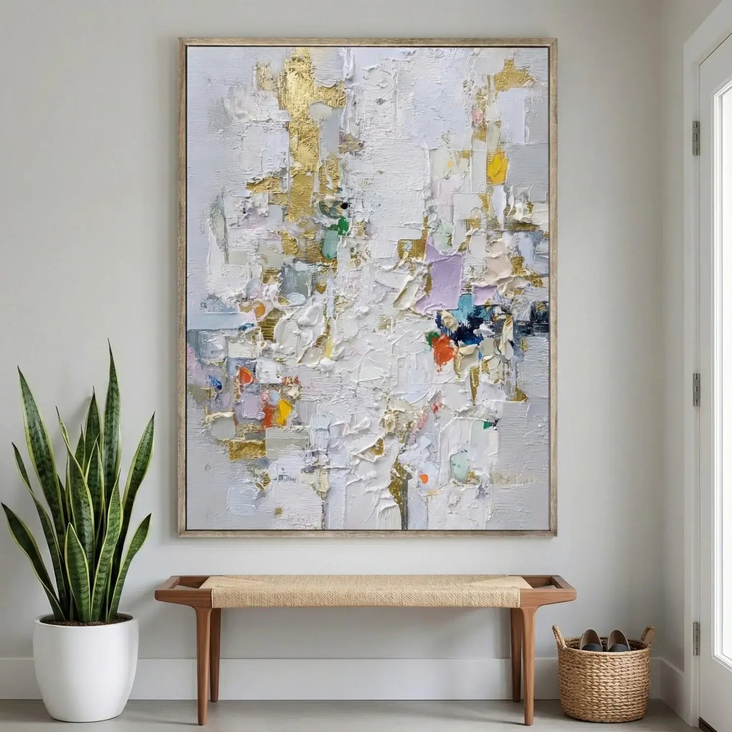 Abstract art piece on a wall with a plant and bench below.