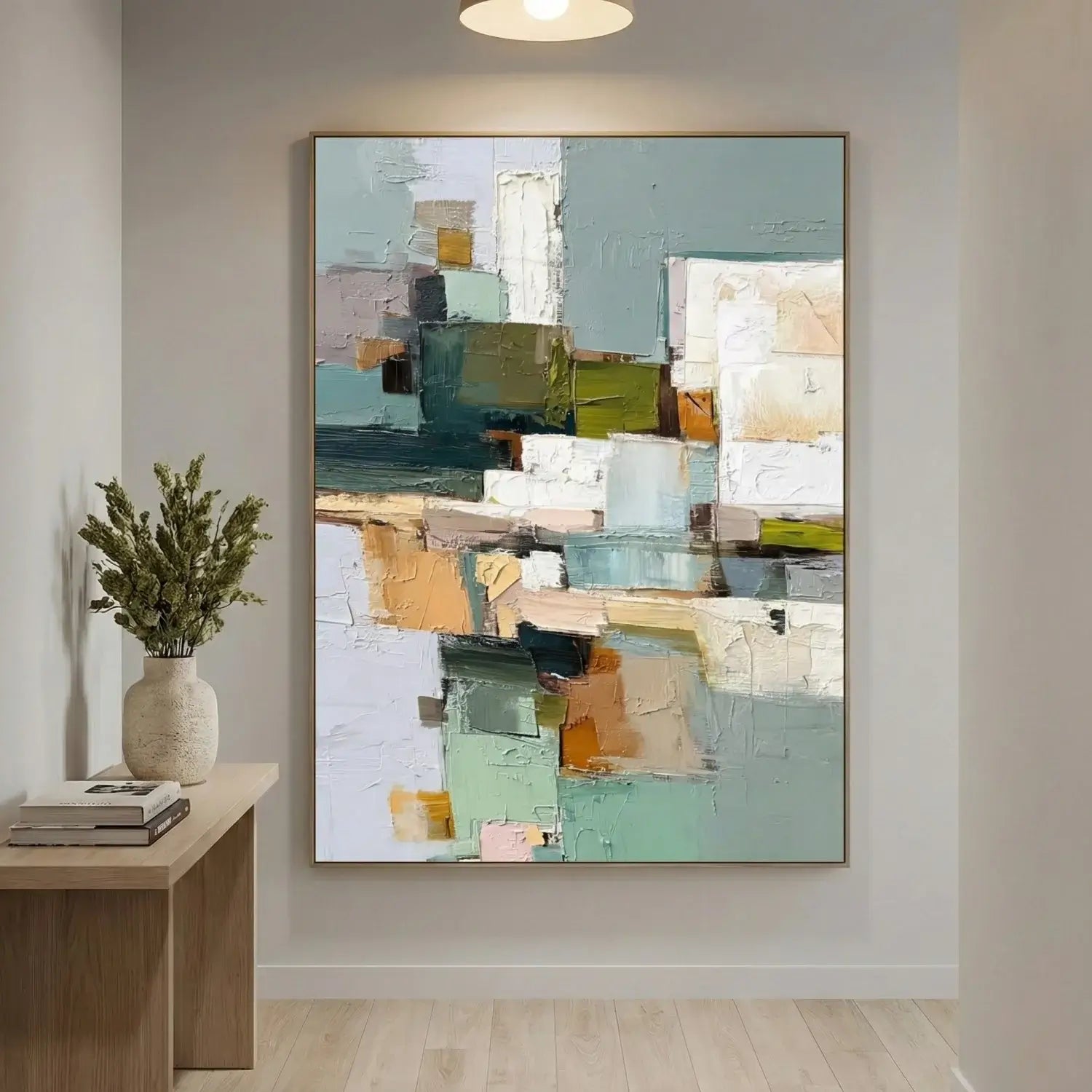 Abstract painting on a wall with a wooden side table and plant in the foreground.