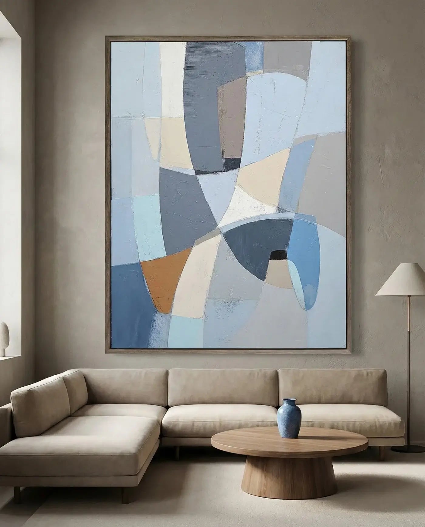 Abstract art piece on a wall above a beige sofa in a living room.