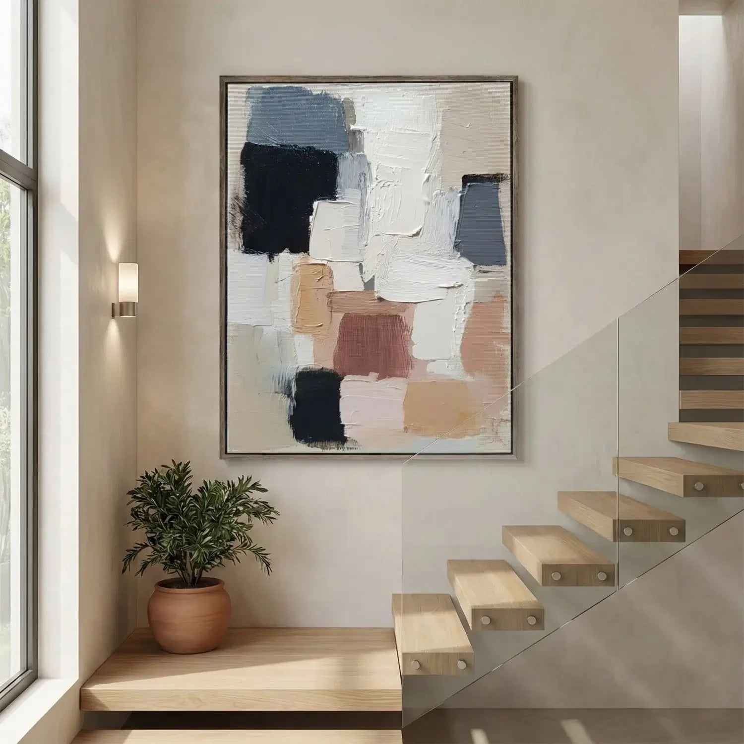 Abstract art piece on a wall above a staircase with a plant nearby