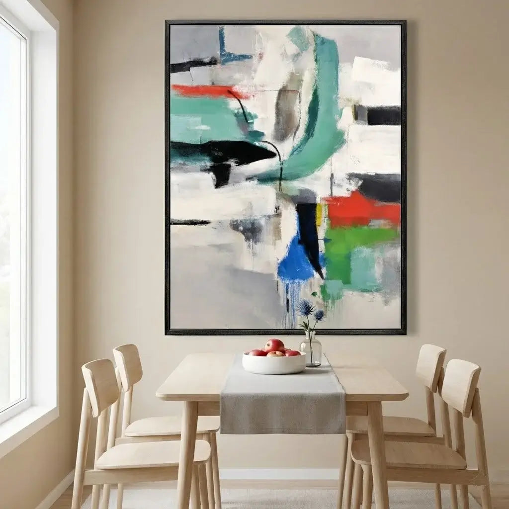 Abstract painting on a wall above a dining table with chairs.
