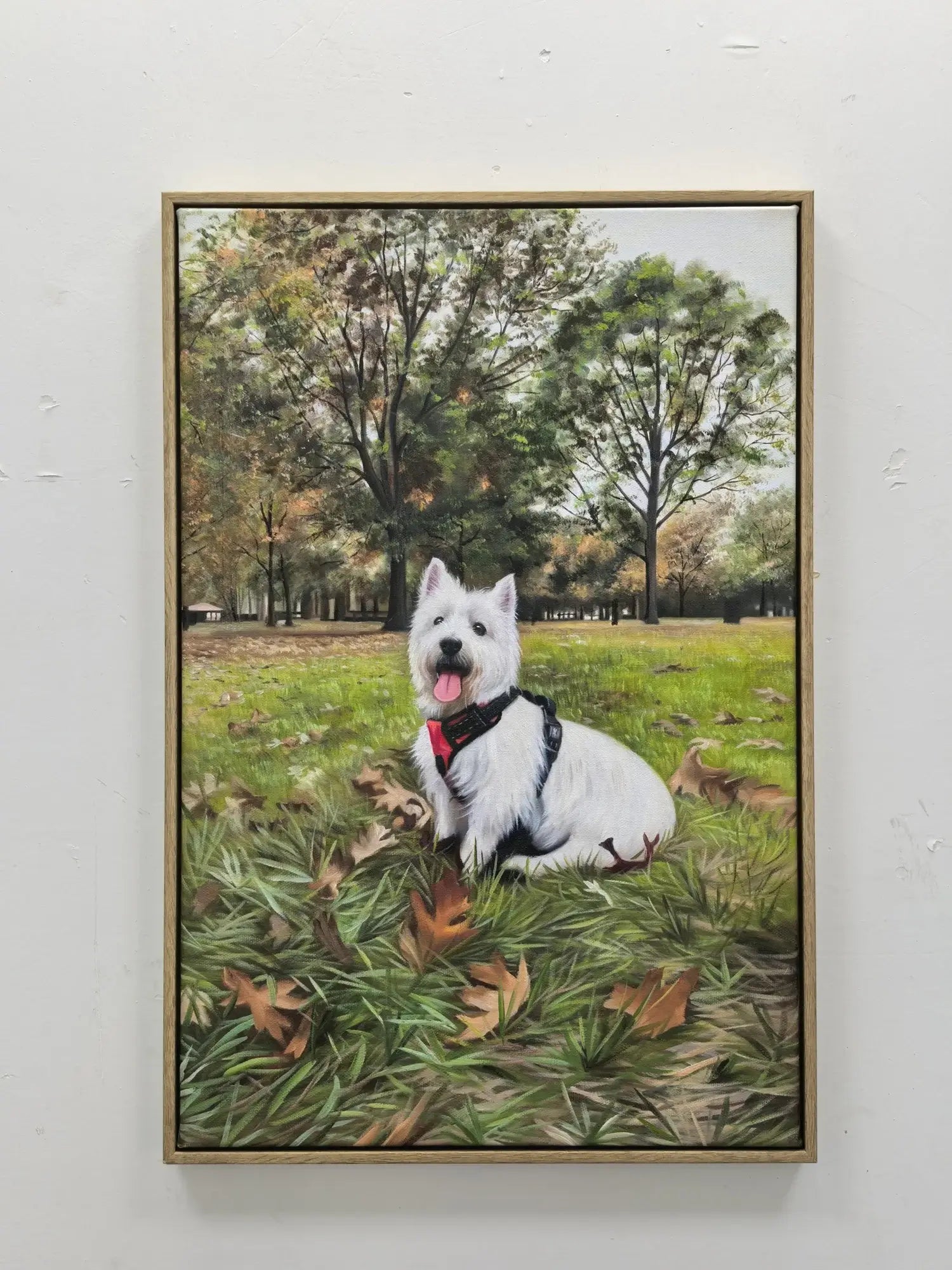 Framed artwork of a white dog sitting in a park with trees and grass.
