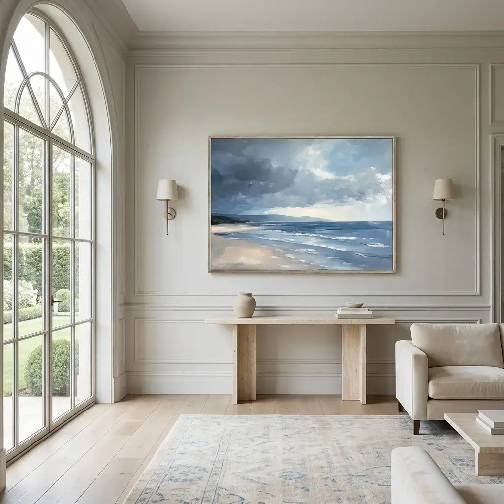 Modern living room with a large window, sofa, and wall art of a beach scene.