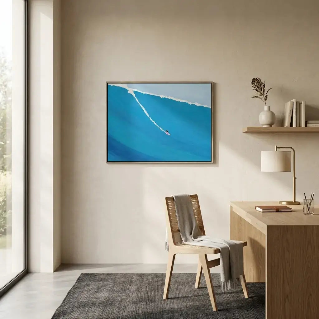 Modern home office with a desk, chair, and wall art of a blue ocean scene.