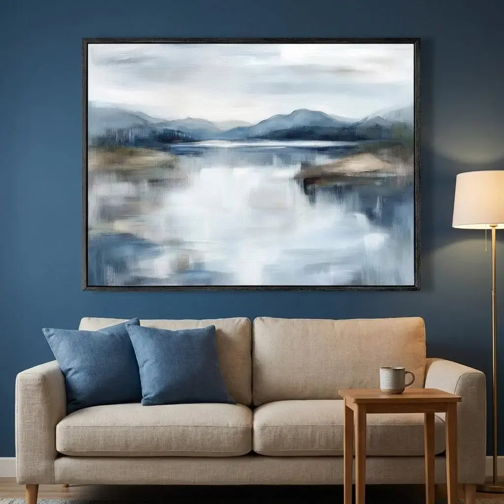 Living room with a beige sofa, blue pillows, a wooden side table, and a large abstract landscape painting on the wall.