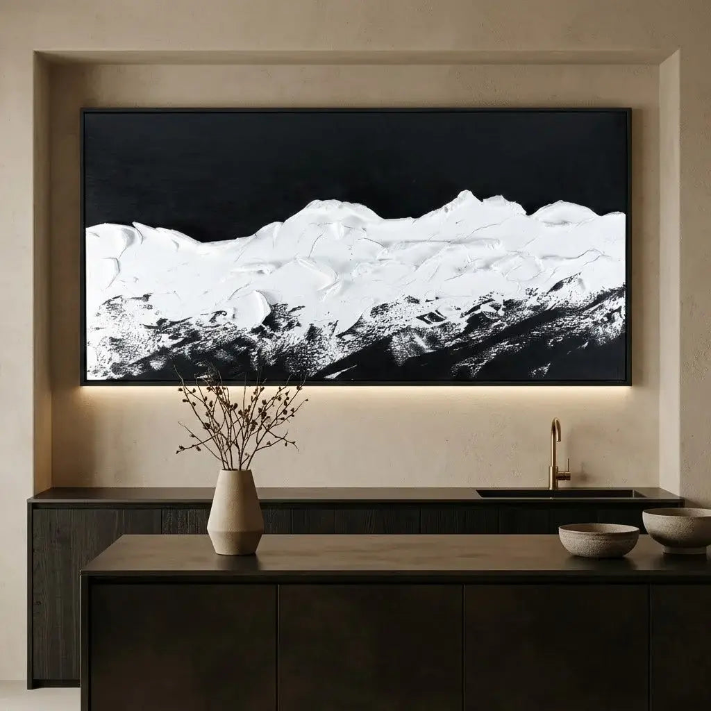 Framed black and white landscape art on a gray wall above a console table.