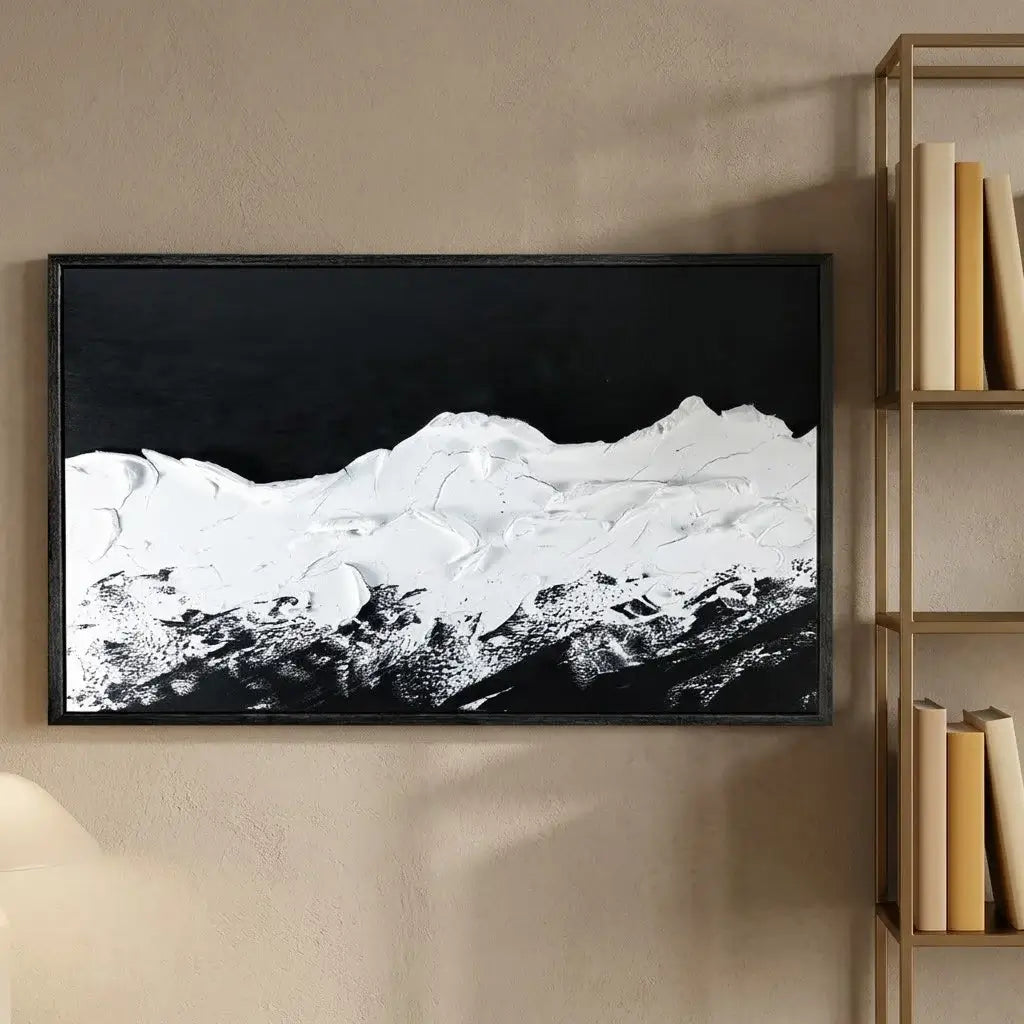 Modern interior with a framed black and white mountain landscape on a marble wall.