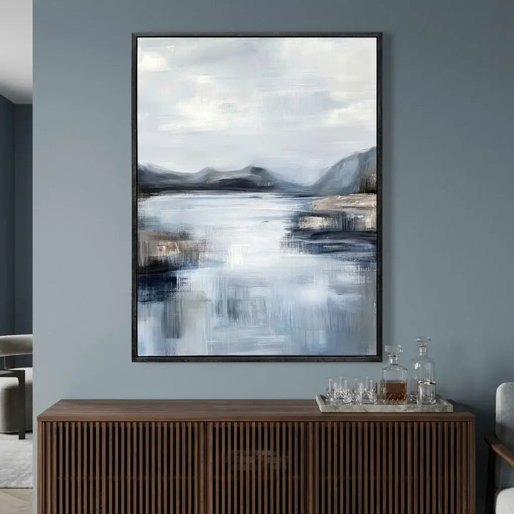 Framed abstract landscape painting on a gray wall above a wooden console table.