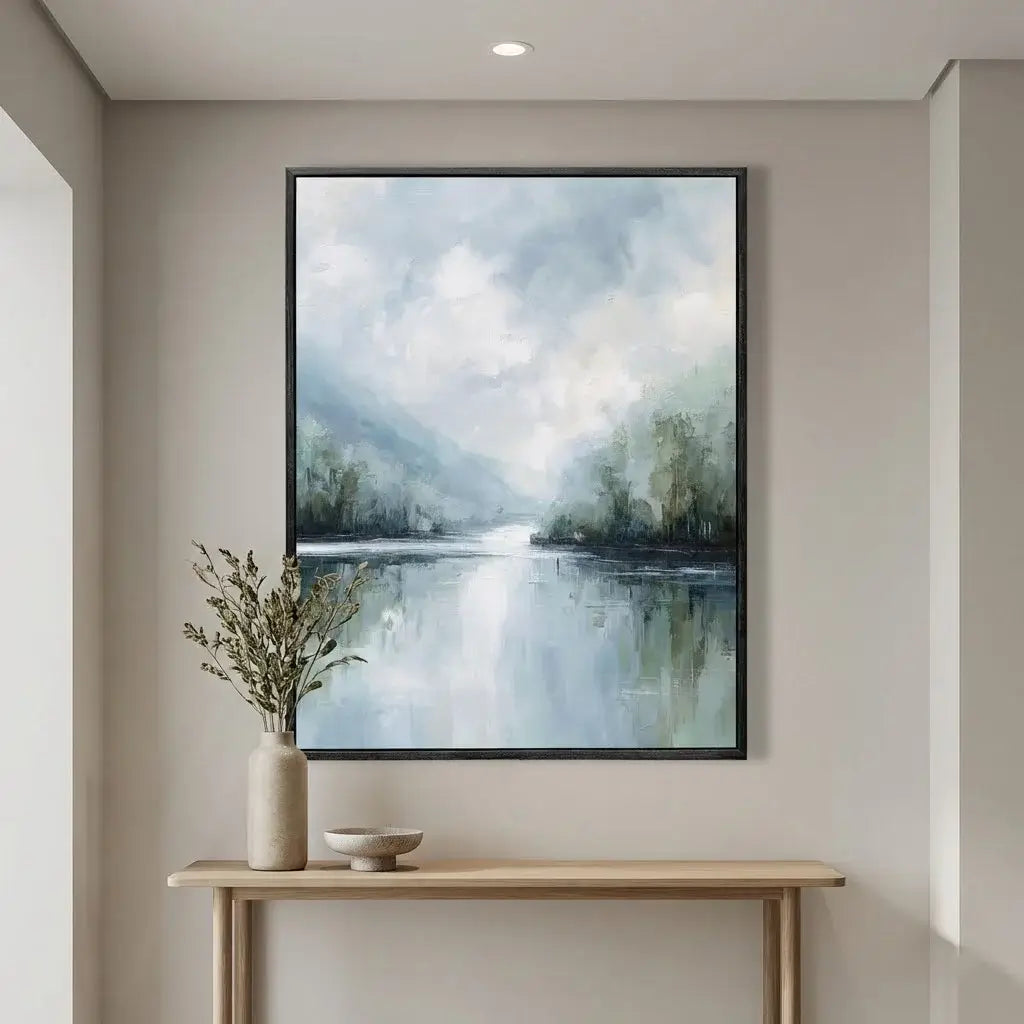 Framed landscape painting above a console table with decorative items.