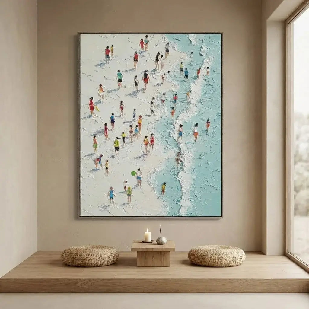 Framed artwork of a beach scene with people on a beige wall above a wooden shelf.