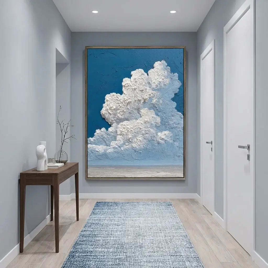 Modern hallway with a large framed artwork of clouds on a blue sky.