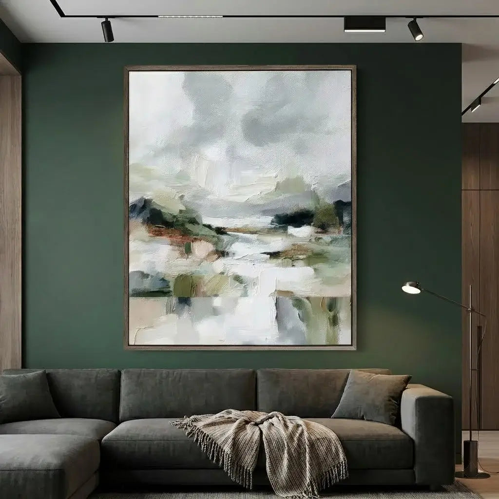 Gray sectional sofa with a blanket against a dark green wall with an abstract painting.