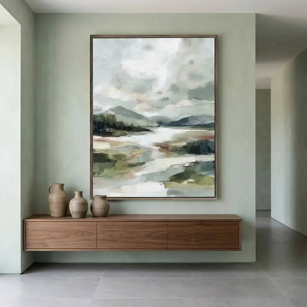 Modern interior with a large abstract landscape painting above a wooden console table.