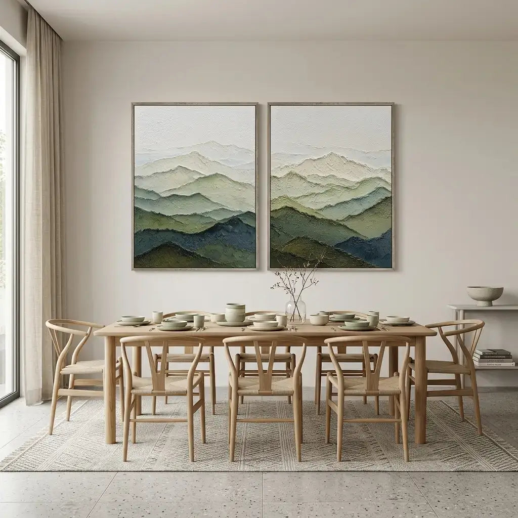 Dining room with wooden table and chairs, and two mountain landscape paintings on the wall.
