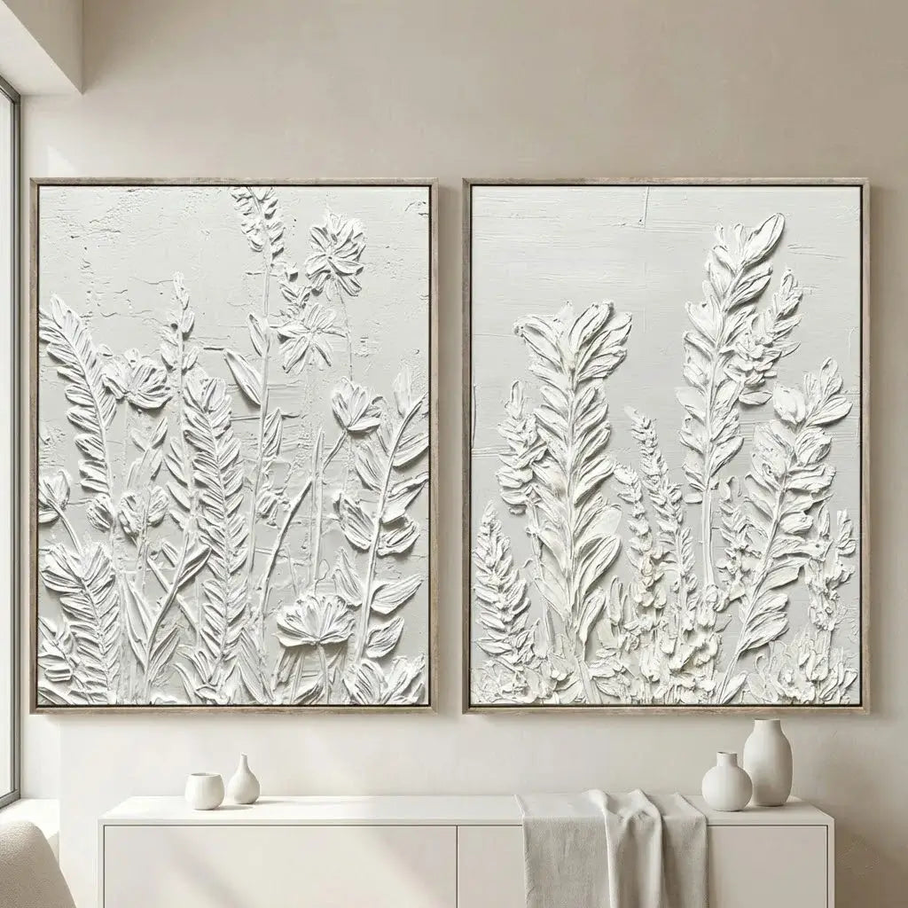 Two framed botanical artworks on a wall with decorative items below.