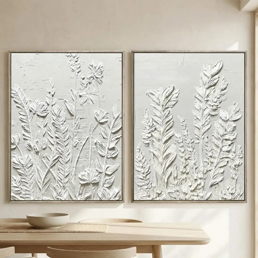 Two framed botanical artworks on a wall above a table.