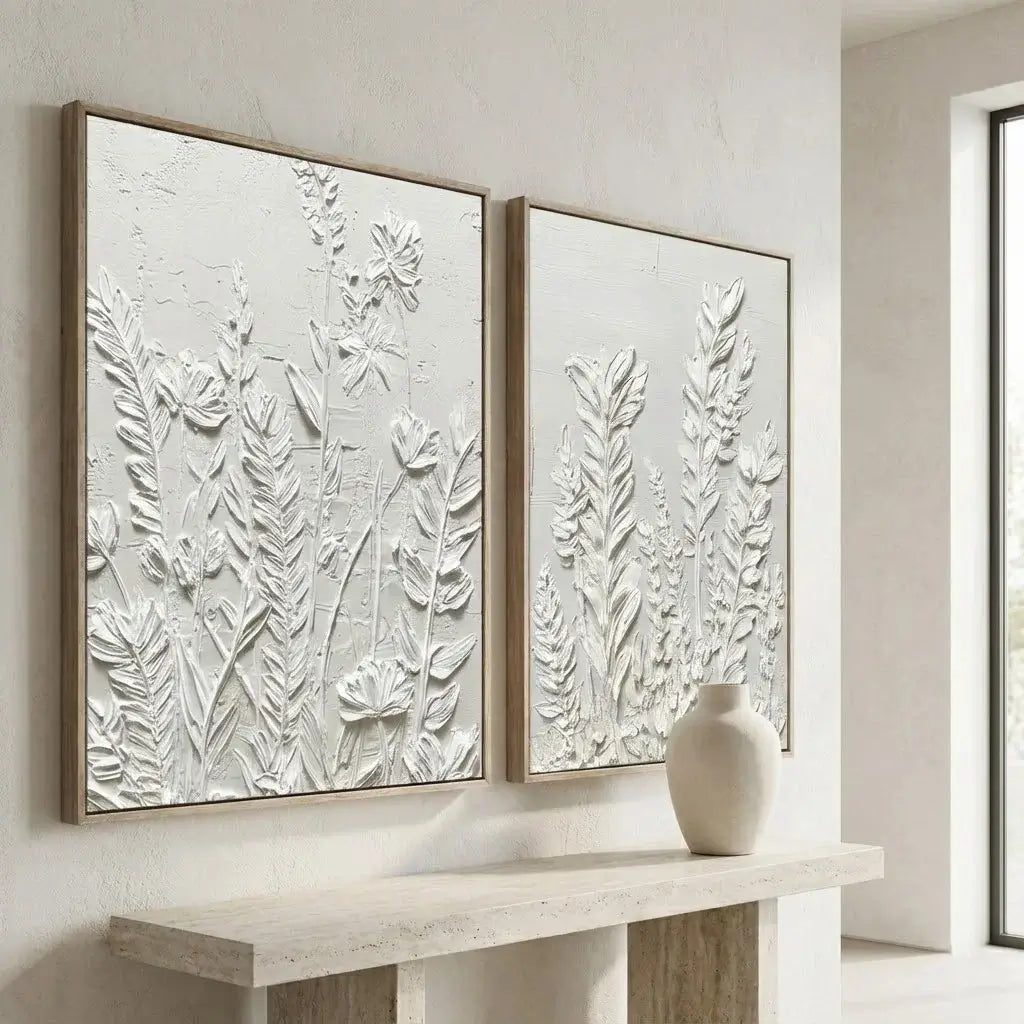 Two framed botanical artworks on a wall above a console table with a vase.