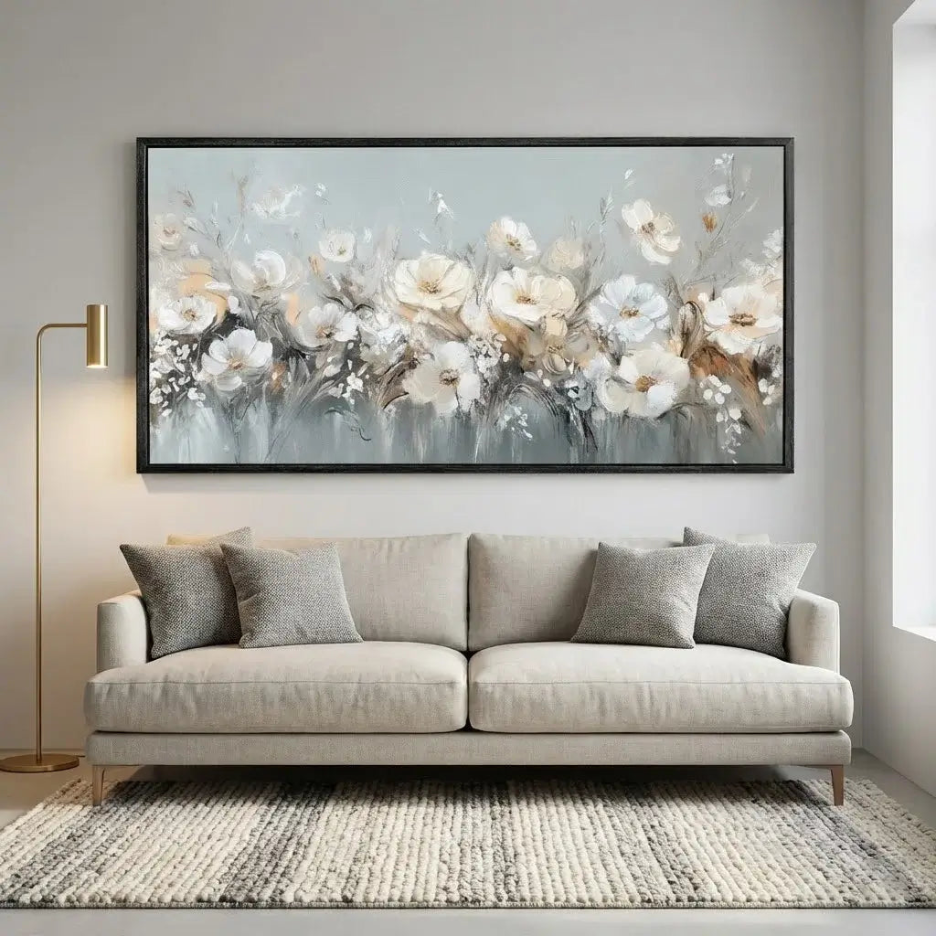 Gray sofa with decorative pillows in a room with a large floral painting on the wall.