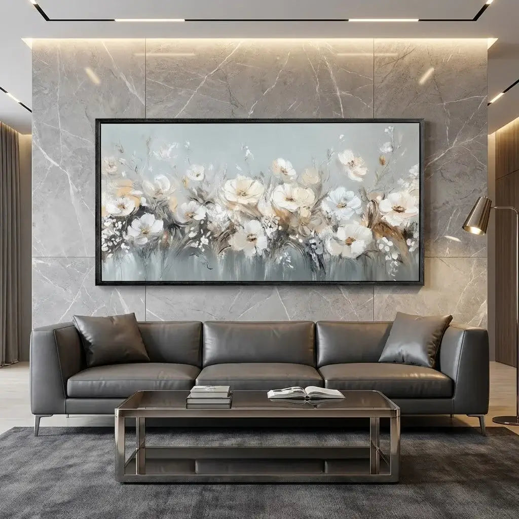 Modern living room with a gray sofa, coffee table, and floral painting on a marble wall.