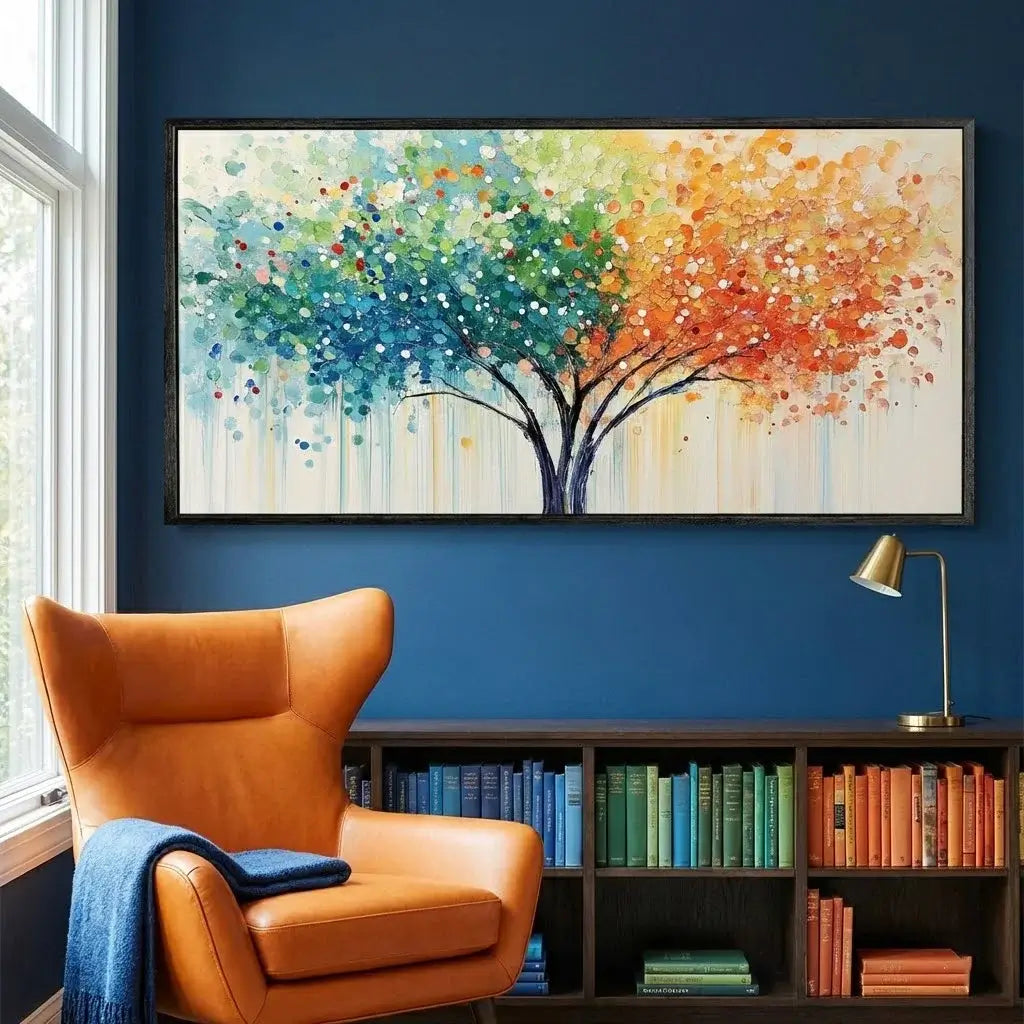 Colorful abstract tree painting on a blue wall above an orange armchair with a bookshelf below.