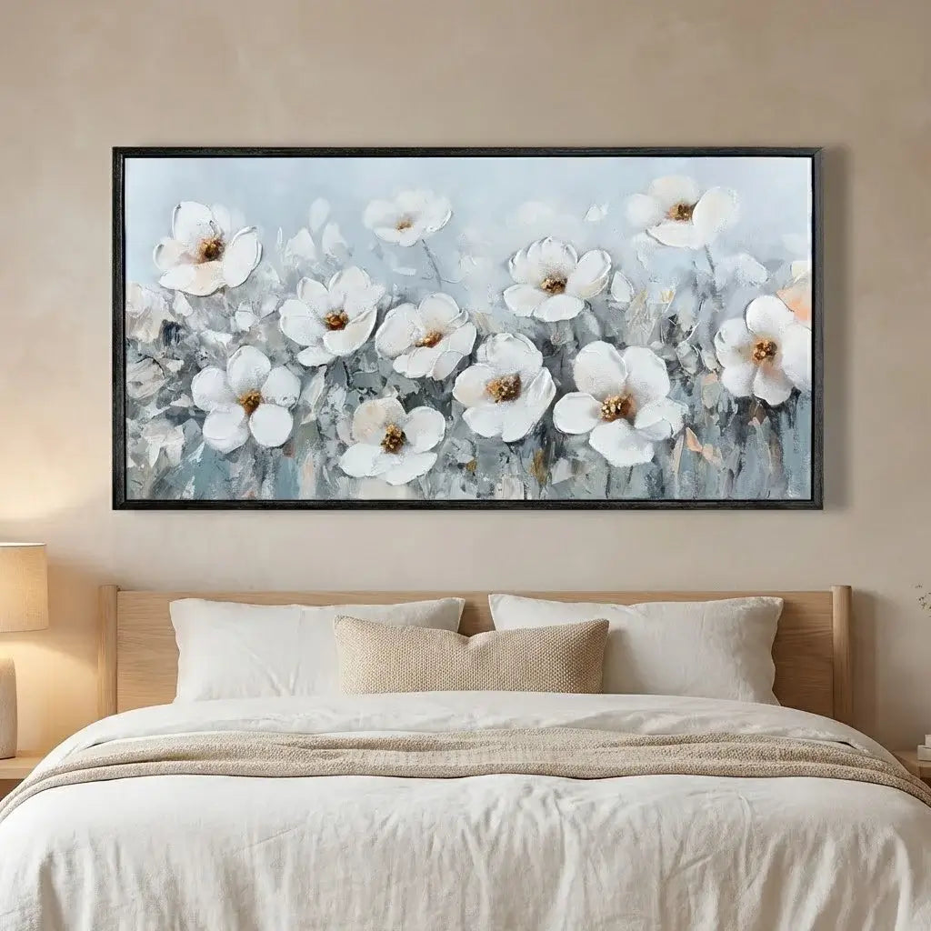 Framed floral artwork above a bed in a bedroom setting
