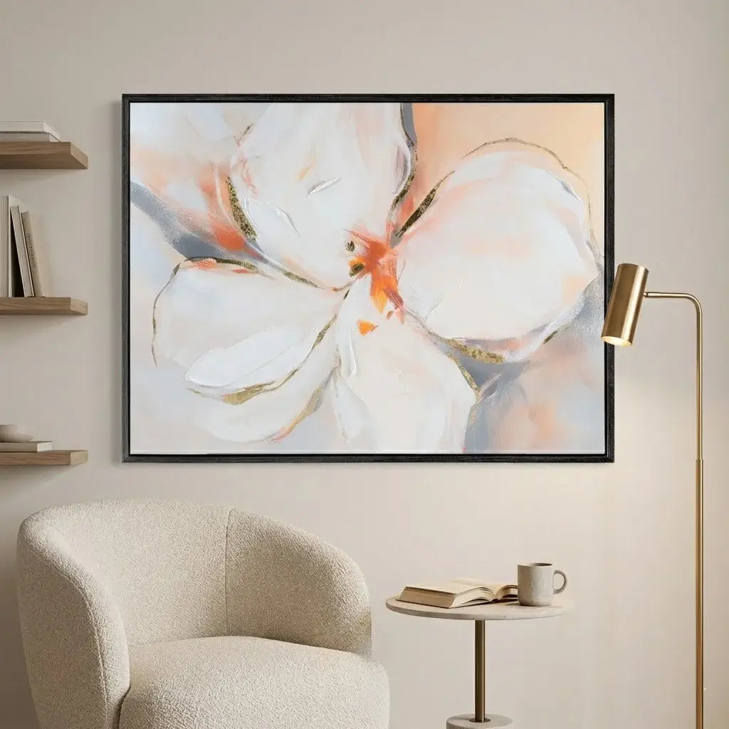 Floral painting on a wall above a chair with a side table and lamp.