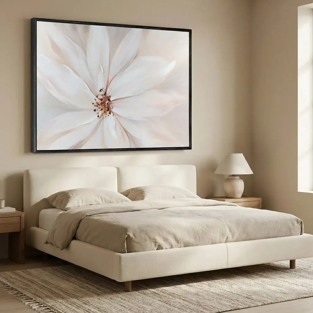 Beige bedroom with a bed, lamp, and floral artwork on the wall.