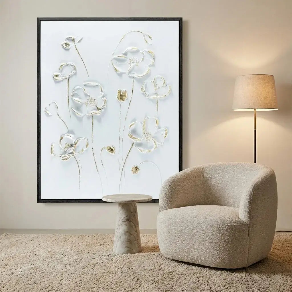 Beige armchair in a room with a floral artwork on the wall and a lamp.