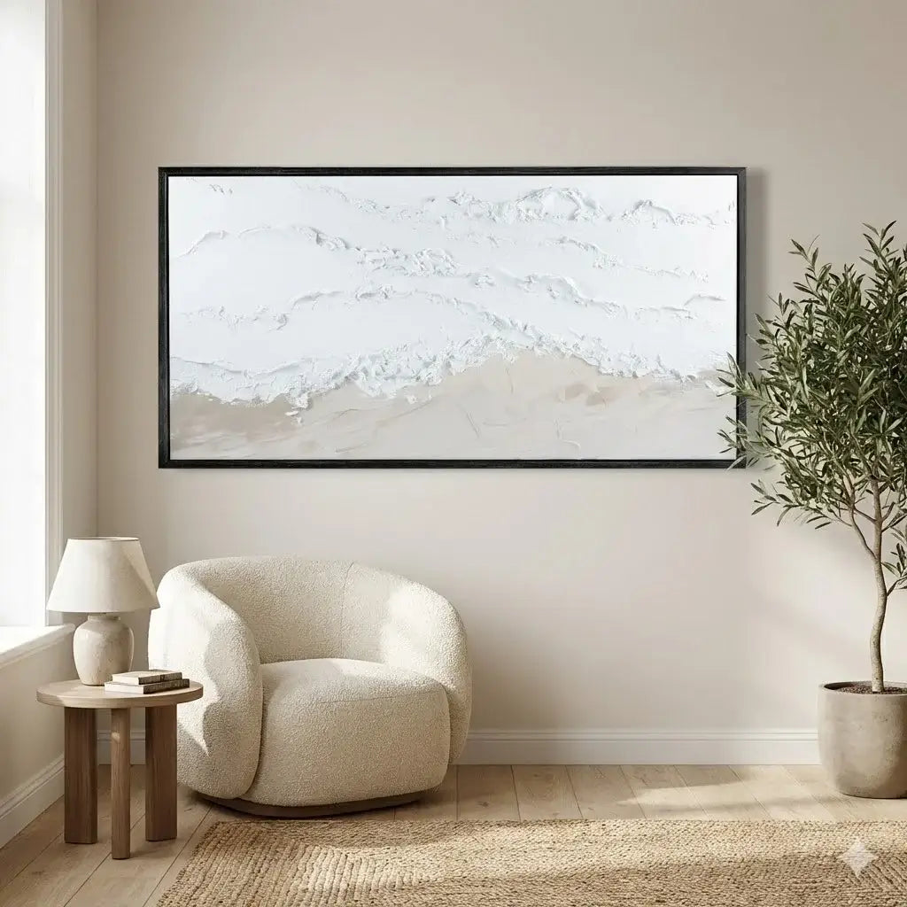 Modern living room with a white armchair, side table, lamp, and abstract painting on a beige wall.