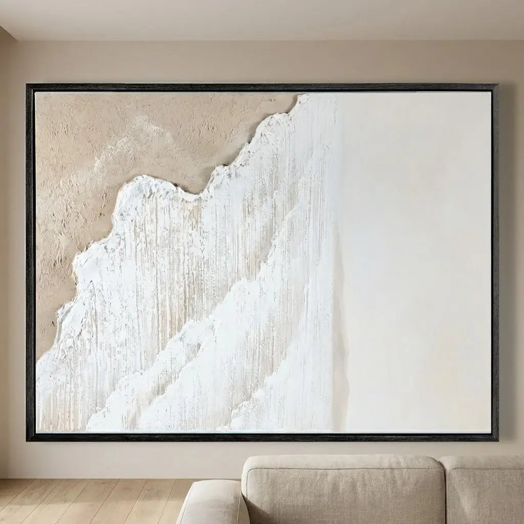 Abstract art piece in a black frame on a wall above a sofa