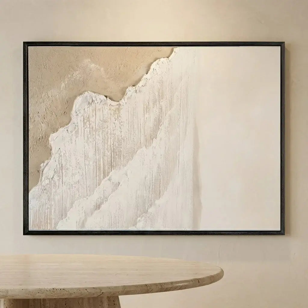 Framed abstract art piece on a wall above a round wooden table.