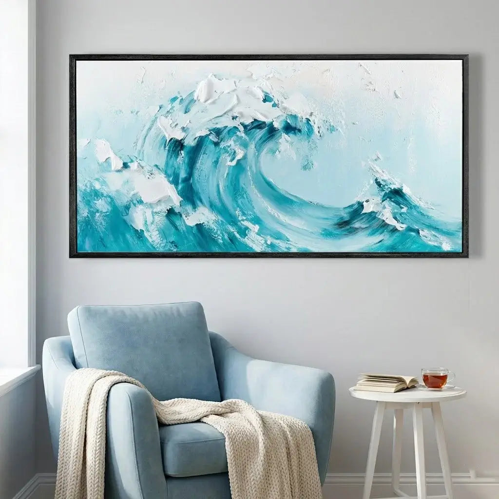 Framed artwork of a blue wave on a wall above a light blue armchair.