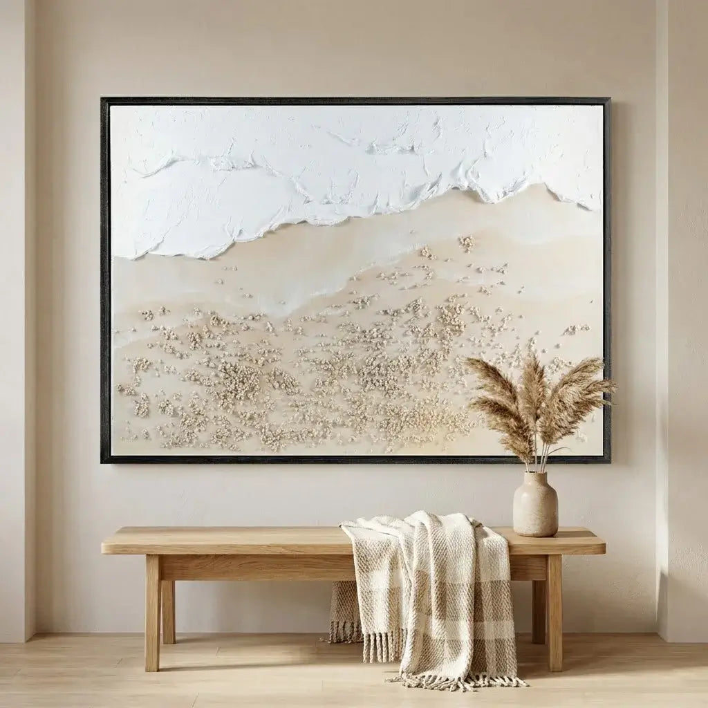 Framed abstract landscape art on a wall above a wooden bench with a plaid blanket and vase.