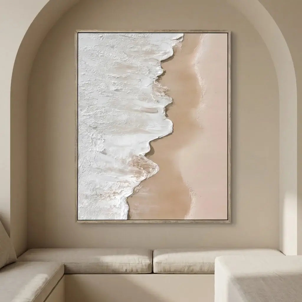 Framed abstract art of a beach scene on a beige wall above a sofa.