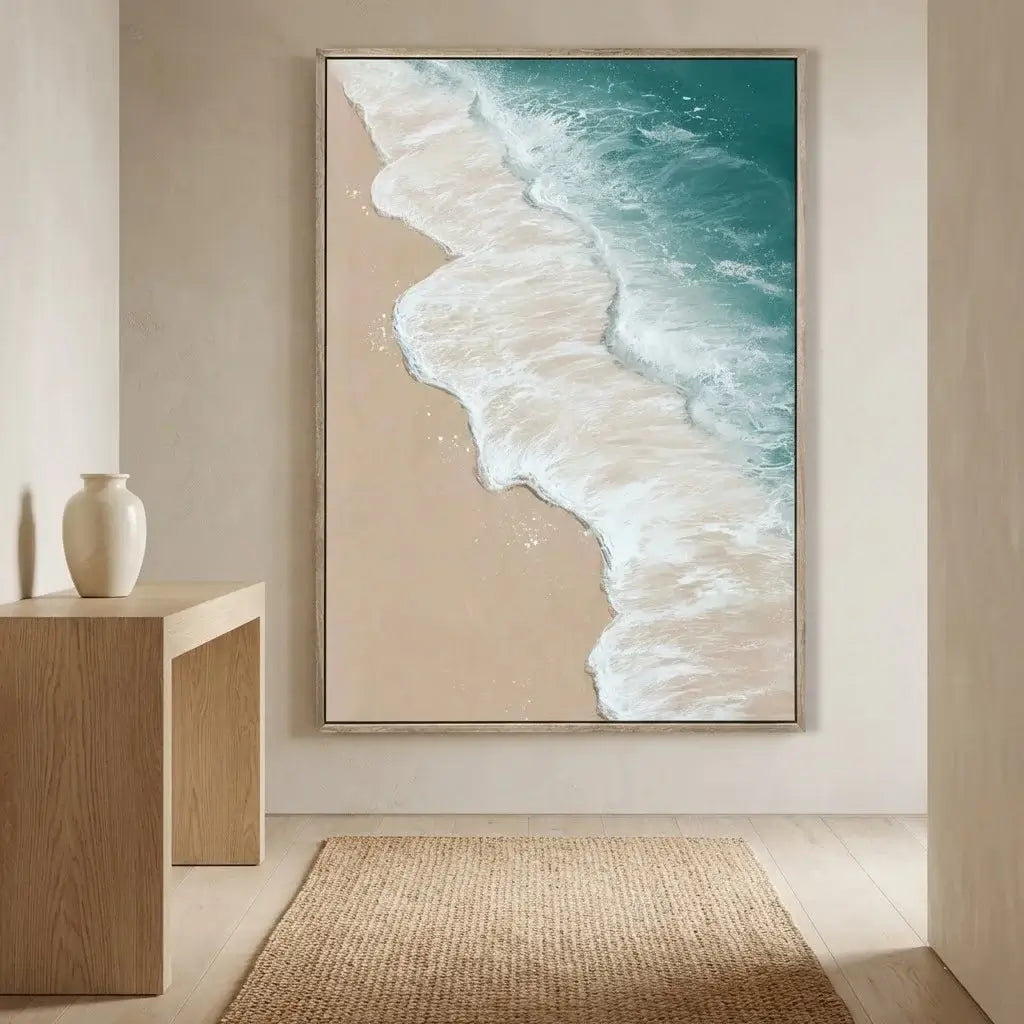 Framed artwork of a beach scene on a wall in a room with a wooden side table and rug.