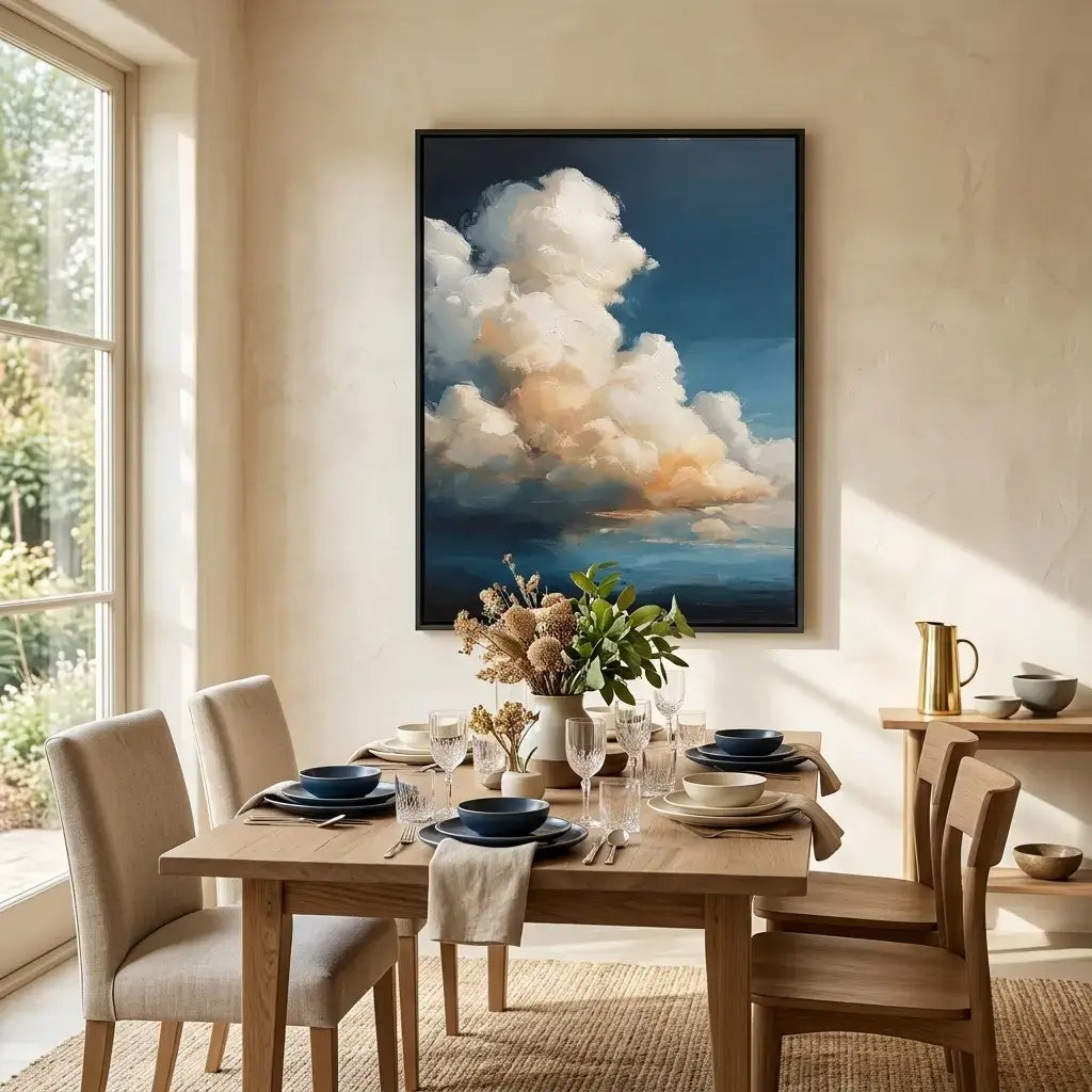 Dining room with a wooden table set for a meal, chairs, and a large framed painting of clouds on the wall.