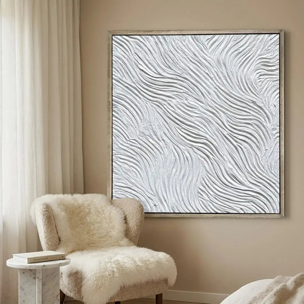Abstract wall art with wavy patterns in a room with a fluffy chair and side table.