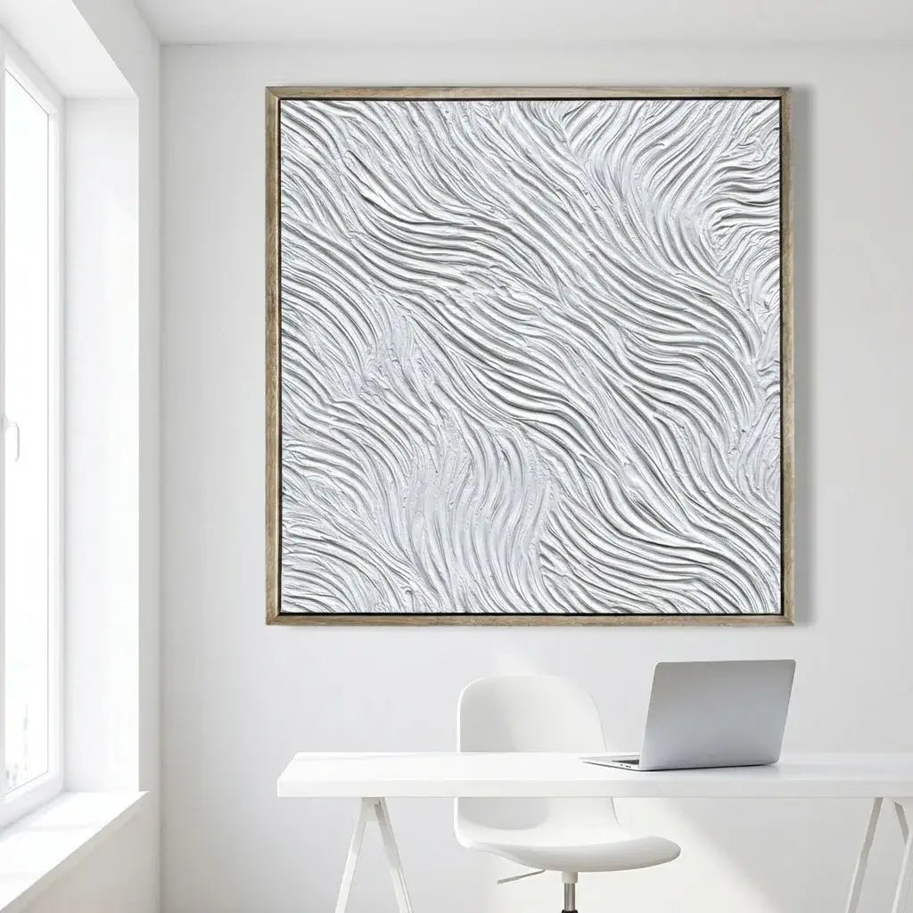 Abstract wavy pattern artwork on a white wall above a desk with a laptop.