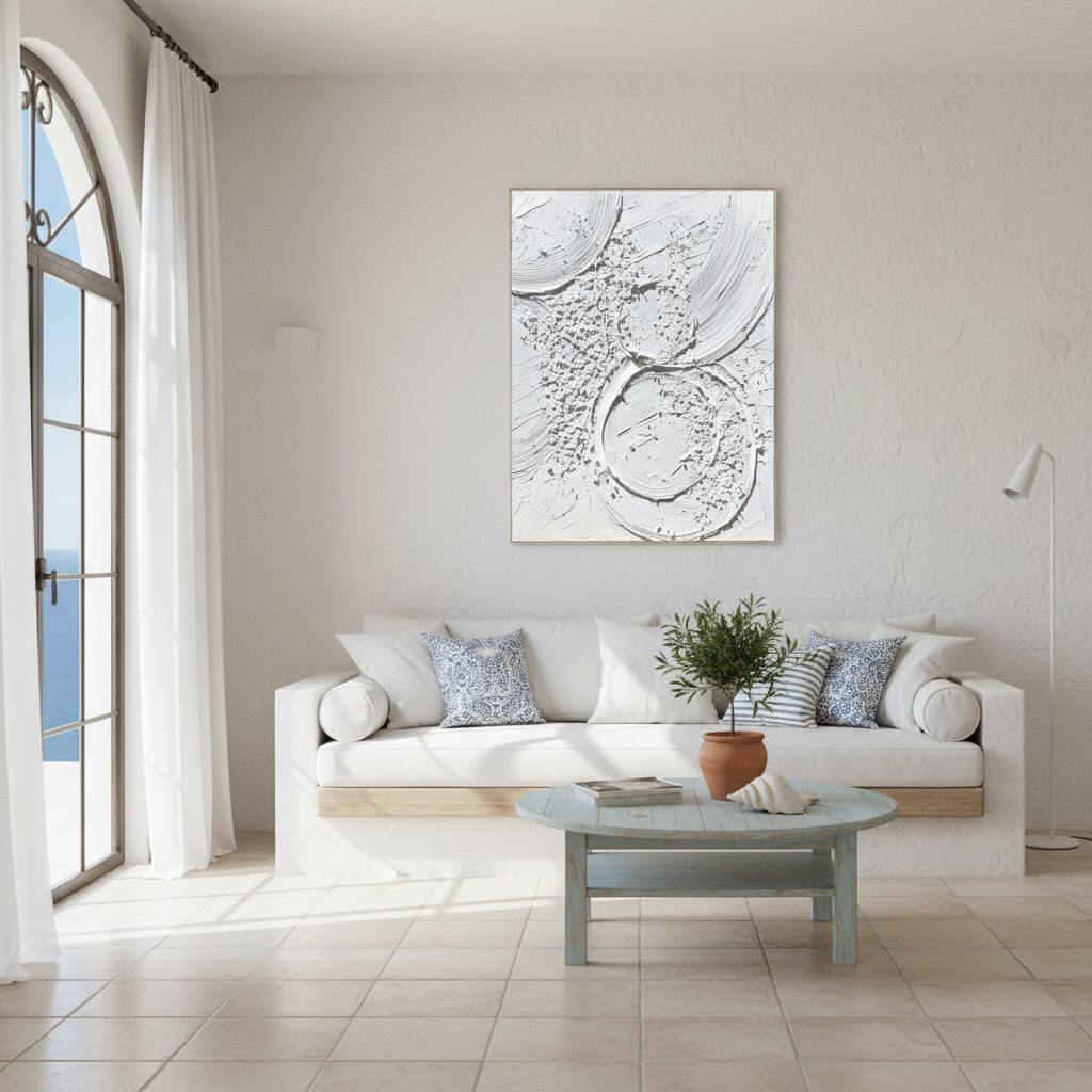 Modern living room with a white sofa, coffee table, and abstract artwork on the wall.
