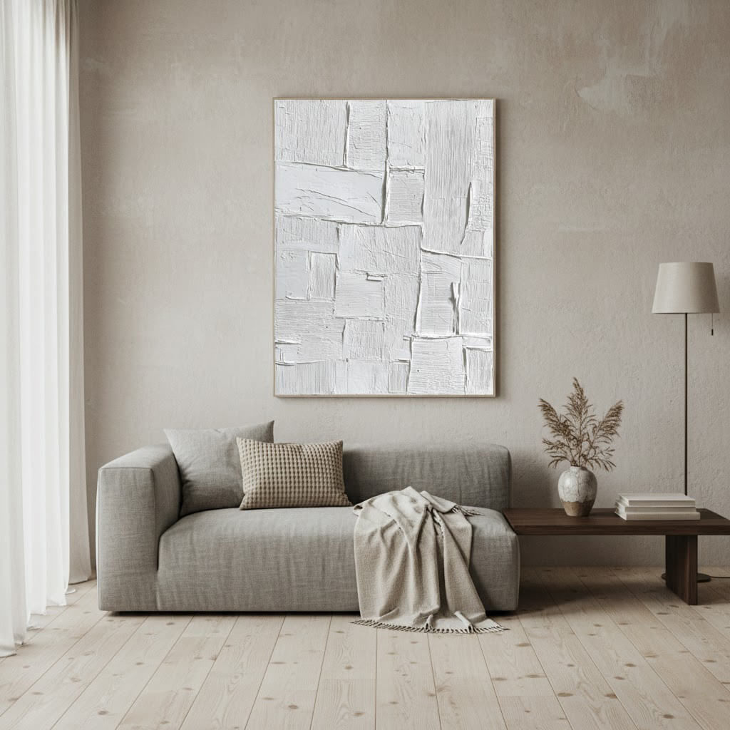 Modern living room with a gray sofa, abstract painting, and minimal decor.