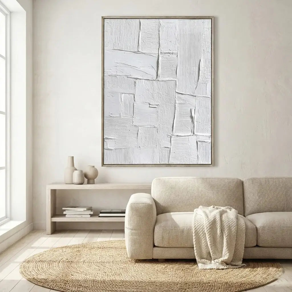 Modern living room with a beige sofa, abstract artwork, and a small table with decor items.