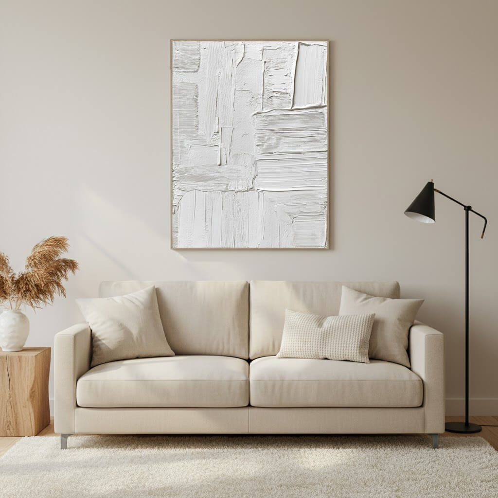 Beige sofa in a living room with abstract art and a lamp.