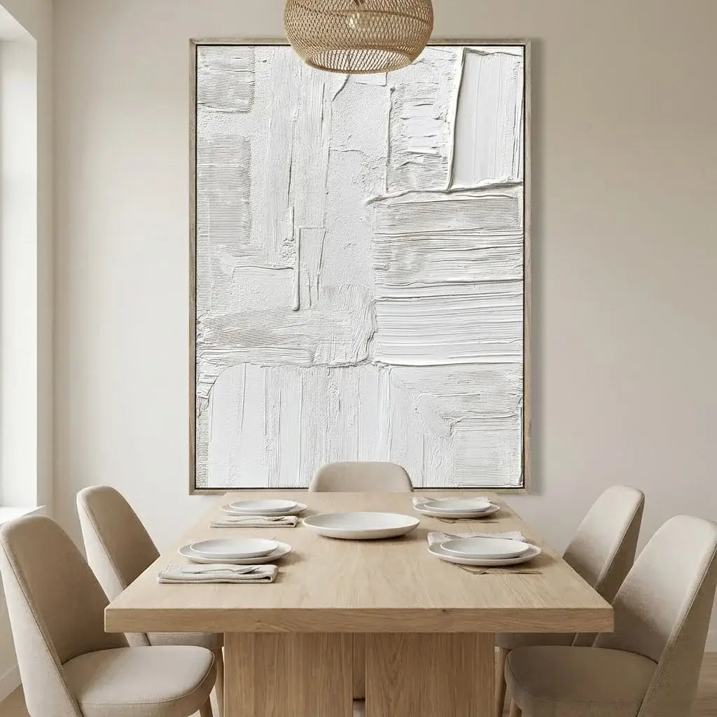 Dining room with a wooden table set for four, abstract art on the wall, and a woven pendant light.