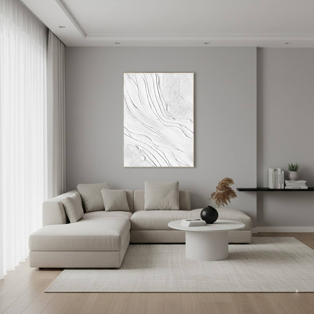 Modern living room with a gray sectional sofa, round coffee table, and abstract wall art.